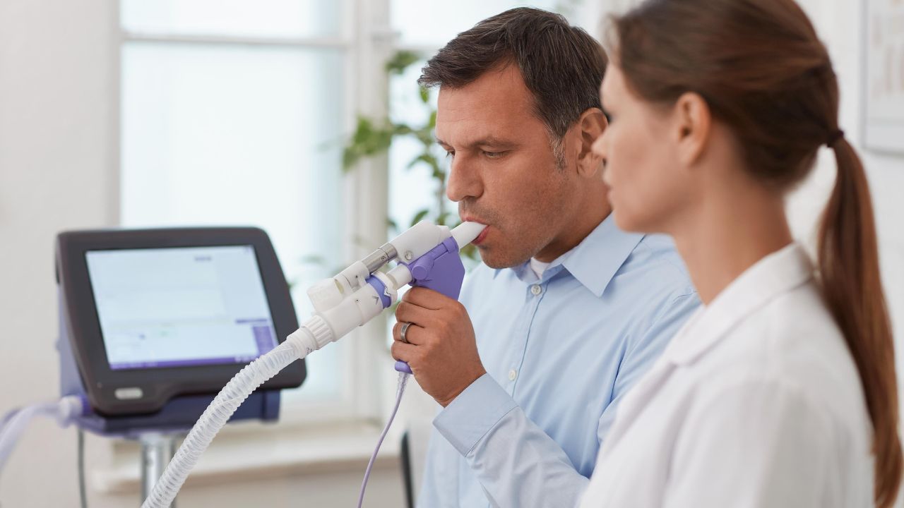 Paciente hombre con doctor mujer realizando una espirometría basal.